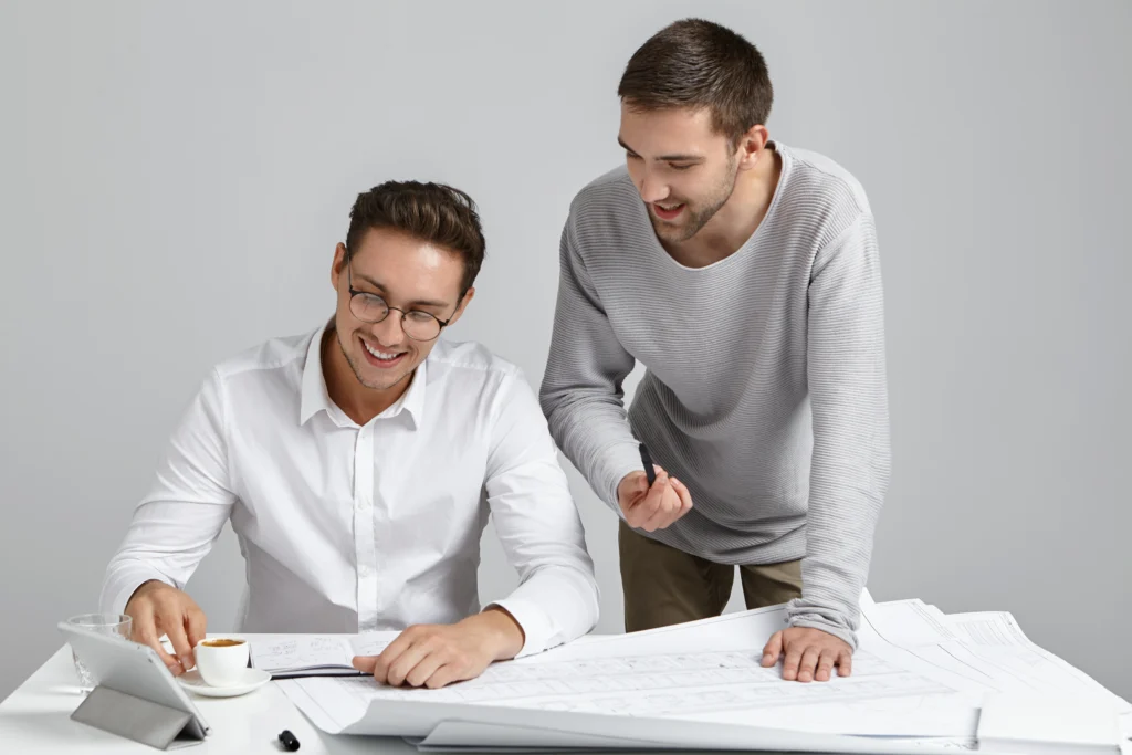 Les Travailleurs Masculins Archirect Se Rassemblent Sur Le Lieu De Travail Entoures D Appareils Electroniques Modernes Et De Plans 1024x683